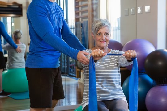 Physiotherapist assisting senior woman in performing stretching