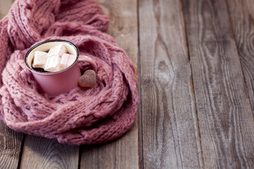 Obraz na płótnie Canvas a cup of coffee with marshmallow and jelly candy in the shape of a heart wrapped in a pink scarf