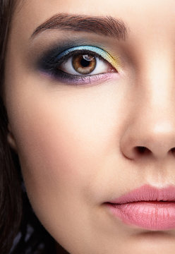 Closeup macro portrait of female face. Human woman half-face  with evening beauty makeup.