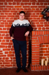 a young man in a New Year's sweater with a deer and New Year's mood