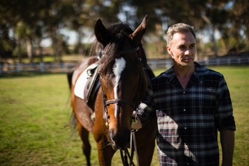 Fototapeta premium Man standing with horse in the ranch