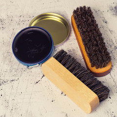       Care products for footwear. Brushes for cleaning shoes and an open jar with cream on a light...