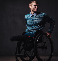 A man in wheelchair over grey background.