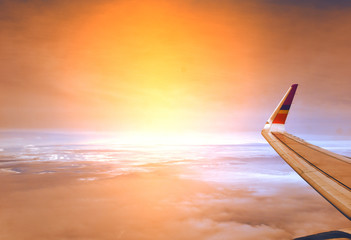 Wing of the plane on twilight sky with sunshine background