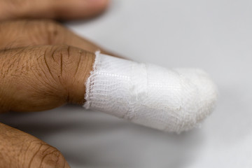 Injured painful finger with white gauze bandage, hand injury, 