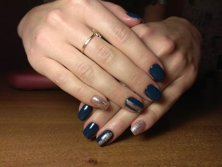 The manicurist excellently made her work a beautiful manicure with a polish gel on her hands and the client is happy