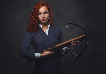 Redhead female  holds crossbow.