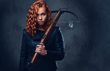 Redhead female  holds crossbow.