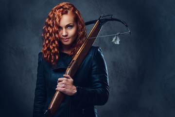 Redhead female  holds crossbow.