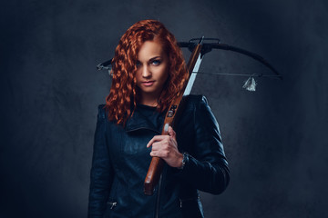 Redhead female  holds crossbow.