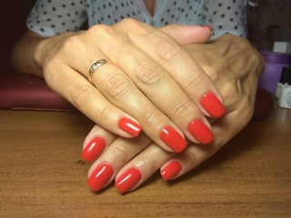 The manicurist excellently made her work a beautiful manicure with a polish gel on her hands and the client is happy