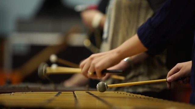 Close up of hands playing marimba in orchestra. Xylophone