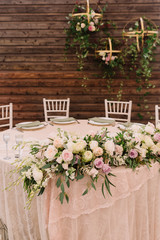 Decorated wedding table in focus in wooden background