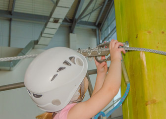 carabiner insurance carries the girl in a white helmet at the adventure Park