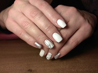 The manicurist excellently made her work a beautiful manicure with a polish gel on her hands and the client is happy