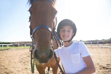 Rider girl standing with a horse in the ranch
