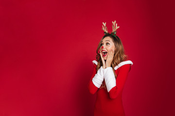 Surprised young woman wearing christmas deer costume.