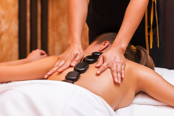 Woman getting thai herbal ball massage treatments in spa.