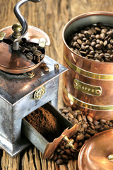 vintage coffee grinder with manufacture roasted Indonesian Arabica coffee beans on rustic wooden...