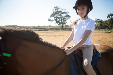 Girl riding a horse in the ranch