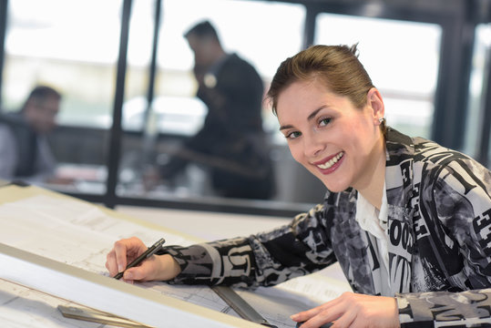 draftswoman works on a drawing in a design office