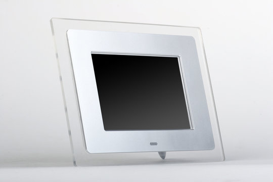 Digital frame with black screen. Transparent glass and silver frame on white background