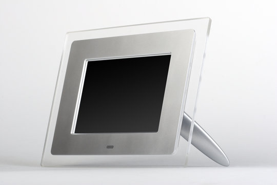 Digital frame with black screen. Transparent glass and silver frame on white background