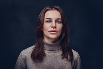 A woman dressed in a long neck brown jacket.