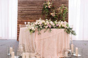Wedding floral table decoration, near candles in transparent vases