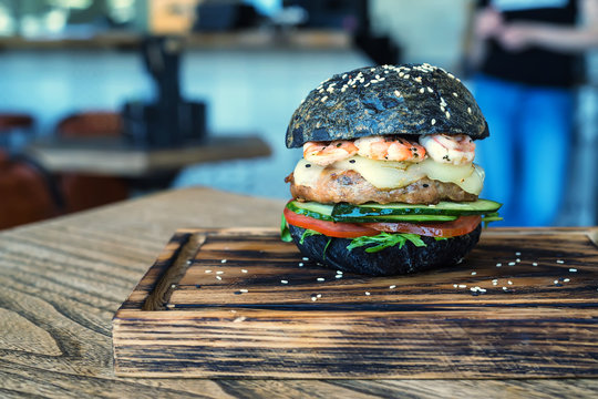 Black Burger With Prawns On Wooden Board