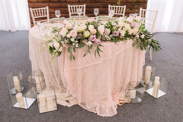 Floral decoration on the table, near candles in transparent vases