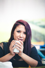 Beautiful girl drinking coffee at the coffee shop