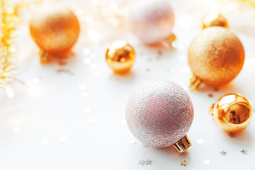 Christmas and New Year background with golden decorative balls for Christmas tree with light bulbs and confetti. Place for text.