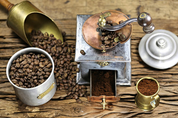 vintage coffee grinder with manufacture roasted Indonesian Arabica coffee beans on rustic wooden background