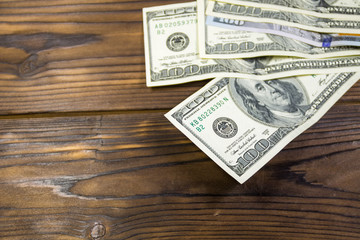 One hundred dollars bills on wooden desk