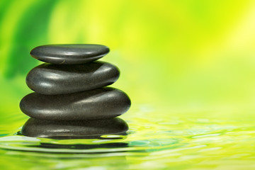 Fototapeta na wymiar black pebbles in balance on rippled water