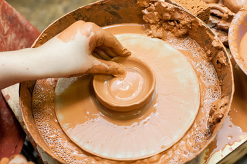 In the pottery workshop. The hands of children learning pottery