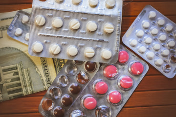 pills and syringe on dollars