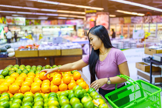 Beautiful asian women shopping vegetables and fruits in supermarket