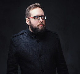 Serious plump male in eyeglasses over grey background.