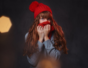 Studio portrait of redhead female over grey background.