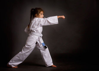 A little girl karate in a white belt, but already received three patches performs kata © sharpner