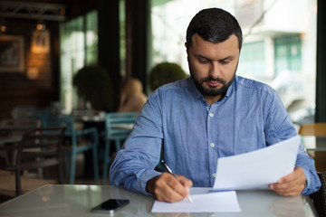 Young businessman writing document