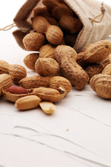 Peanuts in nutshell on white background and peeled peanuts.