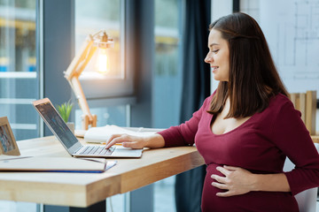 Concentrated pregnant woman with a laptop