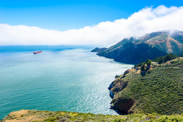 Obraz premium Coast at Golden Gate Bridge in clouds on a beautiful summer day - Panoramic view from Battery Spencer - San Fancisco Bay Area, Golden Gate National Recreation Area, California, USA