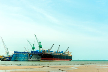 Fototapeta premium Large ship building site dry dock with cargo ship dock next to it.