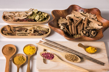 Different herbal and spice in wooden scoop on the table, Various ingredient in container for cooking flat lay on plank