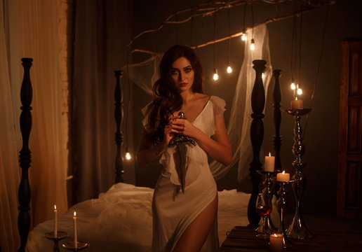 A dark story about mental anguish. A girl with a dagger in her hands carves her heart. Background beautiful gothic interior. Gothic Photography