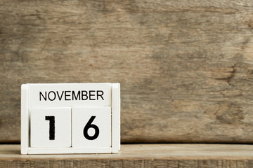 White block calendar present date 16 and month November on wood background